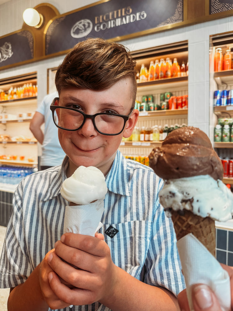 Image of a boy in front of the Palais Garnier while holding his ice cream.