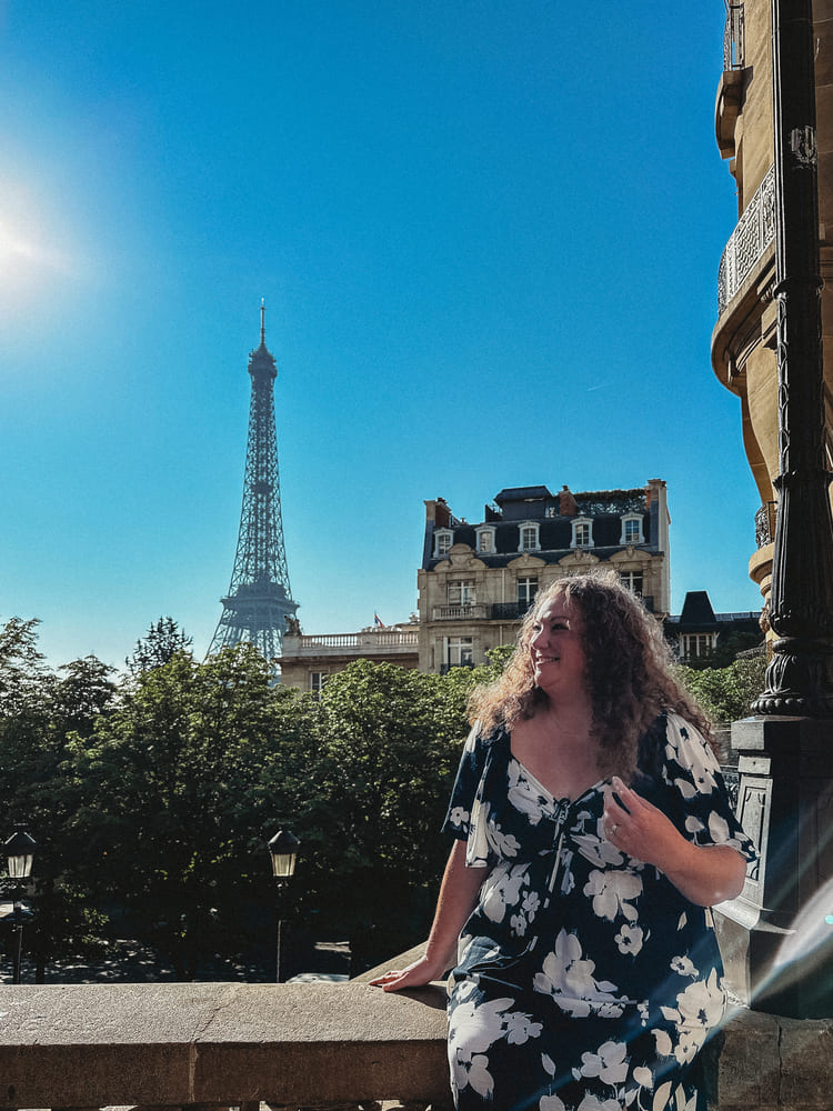 Woman smiling with the Eiffel Tower in the background.