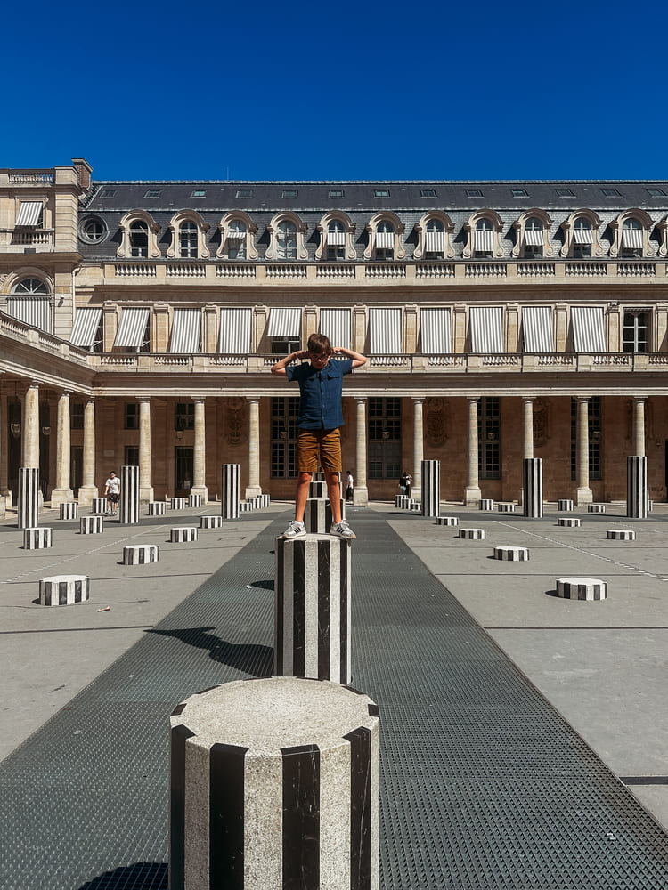 the boy standing on the one of the columns in Palais Royale