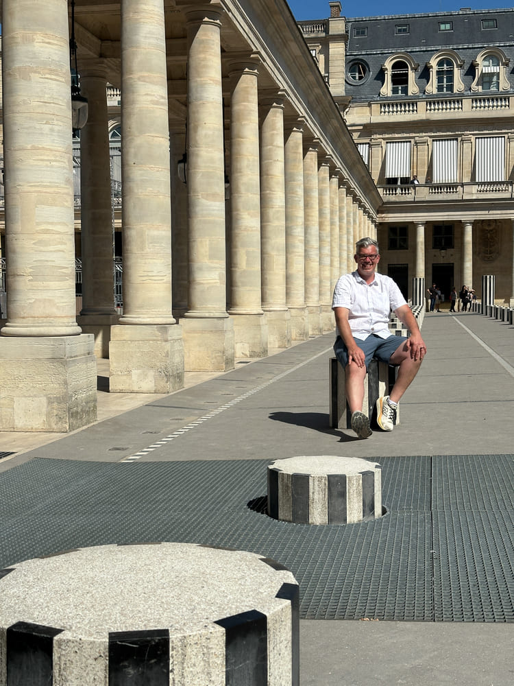 the man taking picture with the black and white columns in Palais Royale