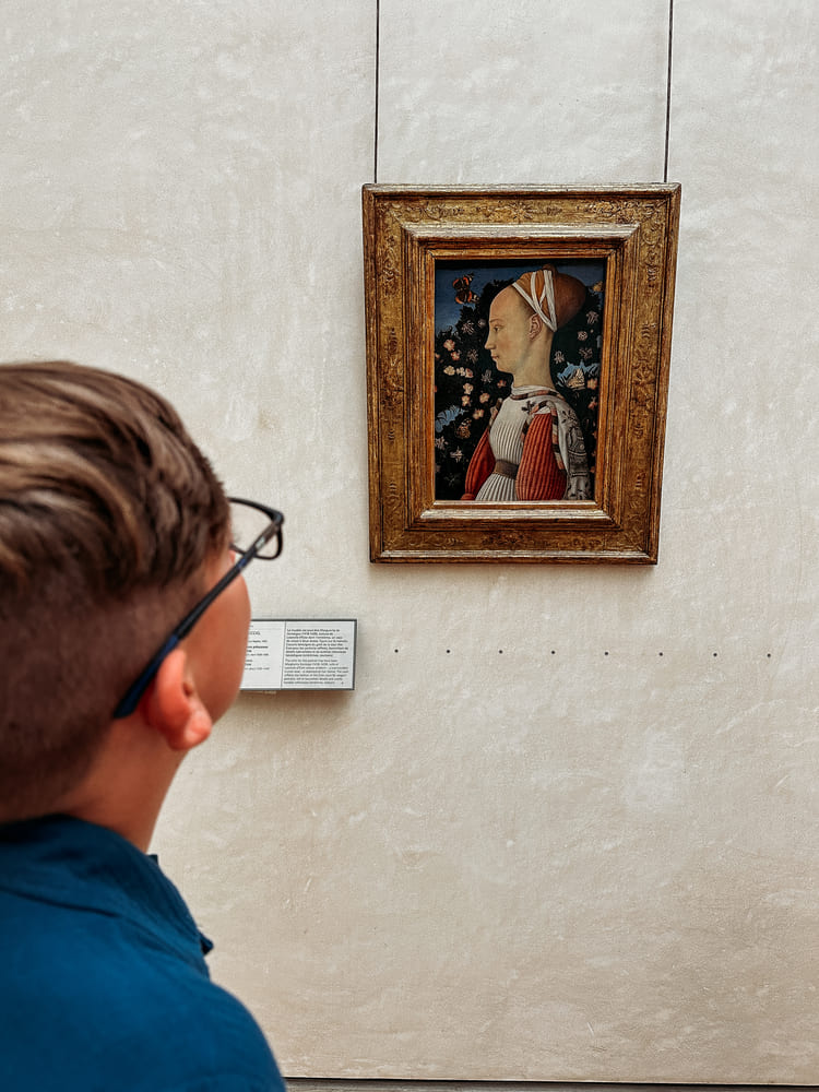 the boy is looking at the painting to find clues for the a kids' scavenger hunt tour