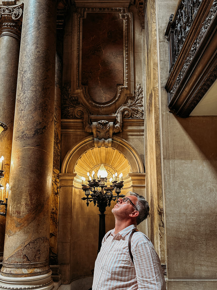 the man looking at the artwork in Palais Garnier