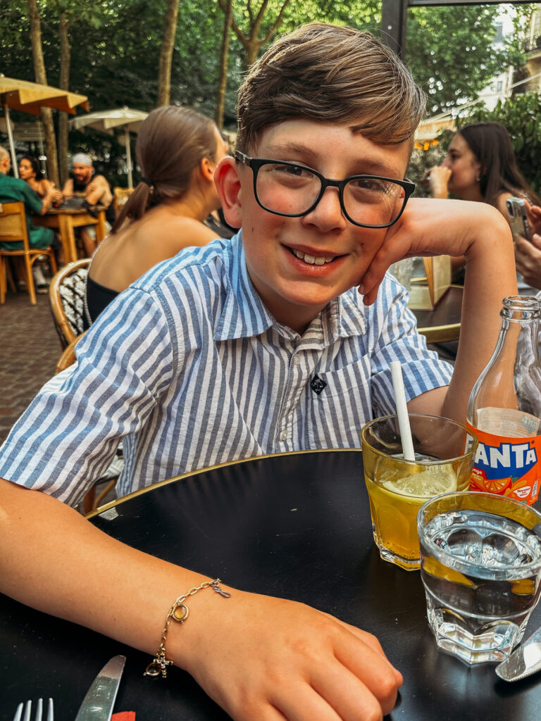 the boy smiling with his handmade charm bracelet