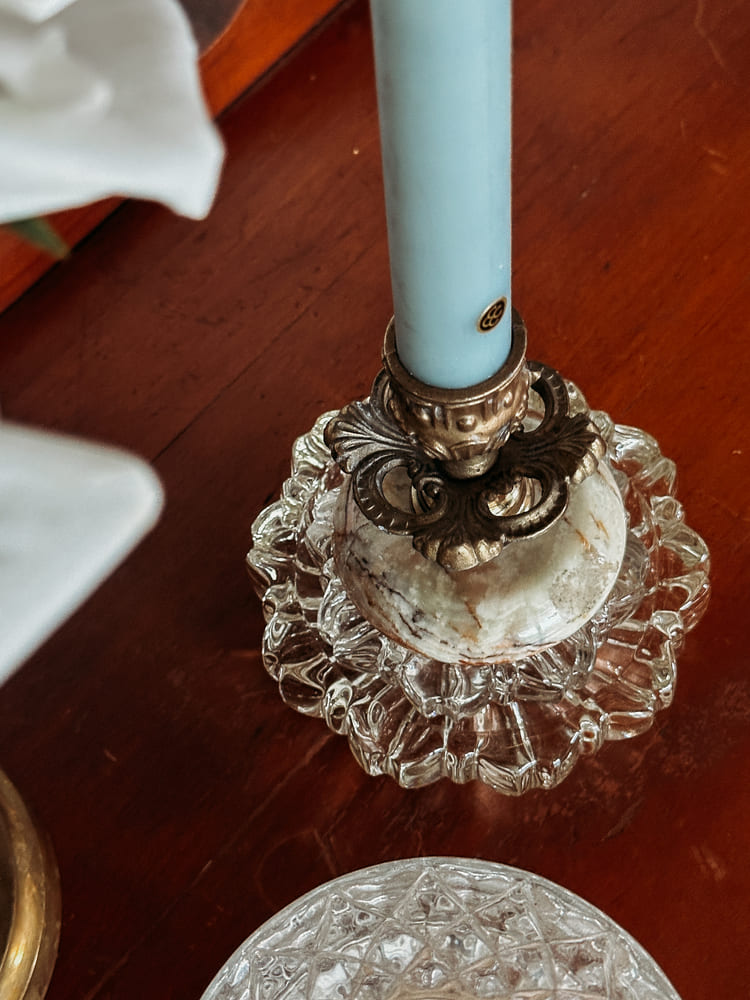 A candle and an elegant plate arranged on a table, enhancing the setting with a cozy ambiance.